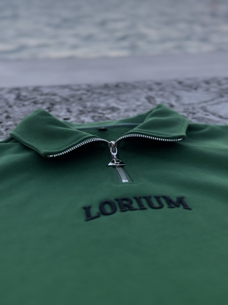 Lorium QZ-001 quarter zip with custom cast-metal triangular zipper pull, 400 GSM heavyweight fleece, collegiate chest embroidery, Kelly Green. Photographed in Miami.